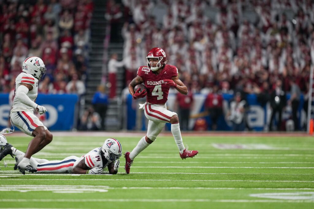 Dec 28, 2023; San Antonio, TX, USA; Oklahoma Sooners wide receiver Nic Anderson (4) runs from Arizona Wildcats safety DJ Warnell Jr. (14) in the second half at Alamodome. Mandatory Credit: Daniel Dunn-USA TODAY Sports