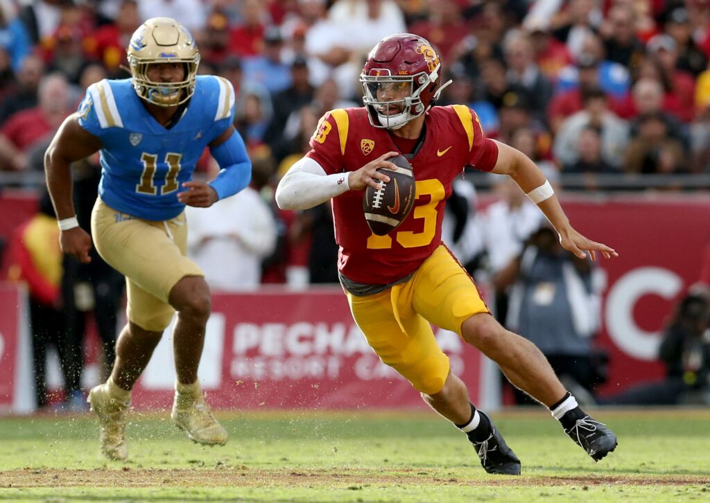 USC Caleb Williams (13 in Red and Gold Jerseys) scrambles in the Trojans Nov 18 game against the UCLA Bruins.