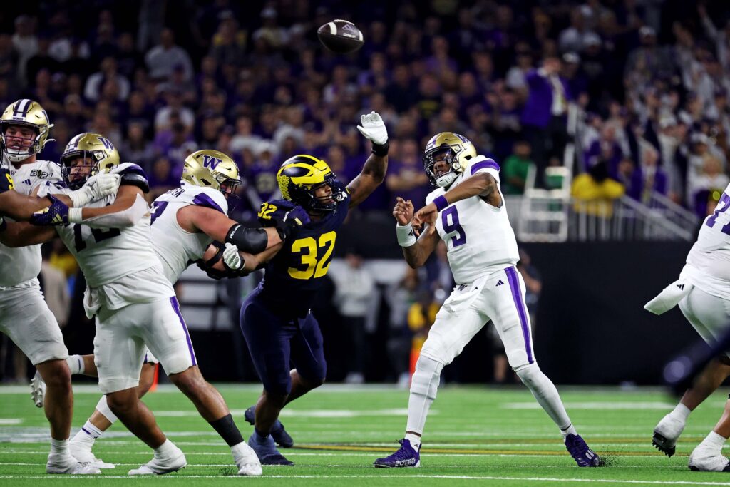 Washington Huskies quarterback Michael Penix Jr. (9) throws a pass against Michigan Wolverines linebacker Jaylen Harrell (32) during the fourth quarter in the 2024 College Football Playoff national championship game at NRG Stadium.