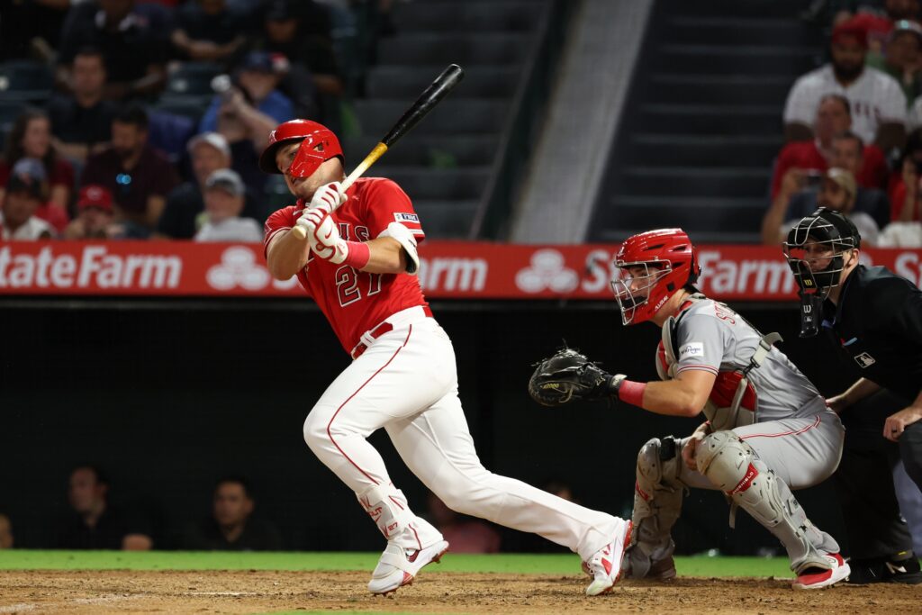 Los Angeles Angels center fielder Mike Trout (27) hits a single during the eighth inning against the Cincinnati Reds at Angel Stadium.