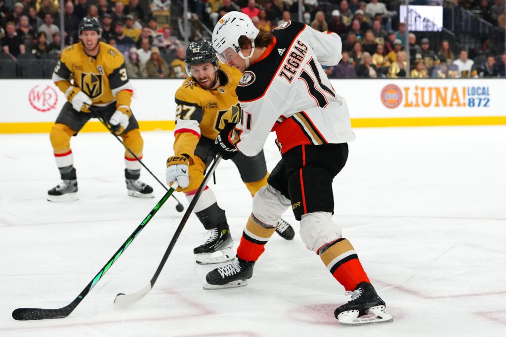 Anaheim Ducks center Trevor Zegras (11) shoots against the stick of Vegas Golden Knights defenseman Shea Theodore (27) during the first period at T-Mobile Arena.