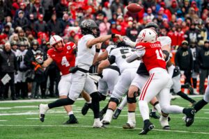 Purdue Boilermakers quarterback Hudson Card (in the white jersey, white pants and black and gold helmet) throws the ball under pressure from Nebraska pass rush on Oct. 28, 2023 at Memorial Stadium in Lincoln. 