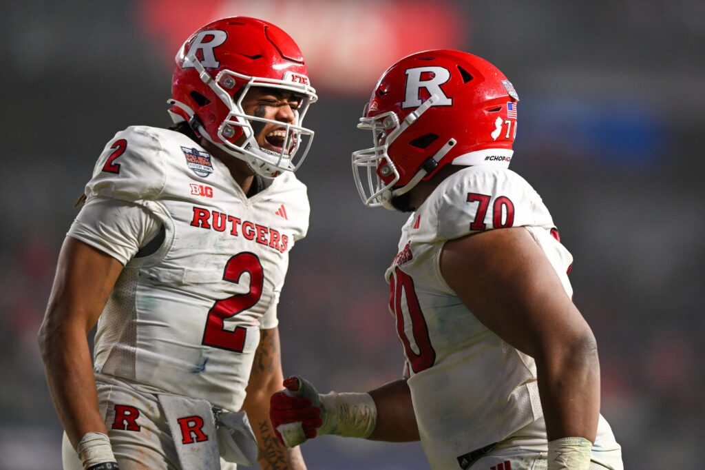  Rutgers Scarlet Knights quarterback Gavin Wimsatt (2) celebrates a touchdown with Rutgers Scarlet Knights offensive lineman Reggie Sutton (70) during the fourth quarter against the Miami Hurricanes at Yankee Stadium. 