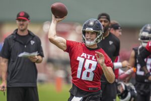 New Atlanta Falcons quarterback Kirk Cousins (In red and white jersey, black helmet, black pants) throws during the Falcons OTA on June 3, 2024 in Atlanta. 