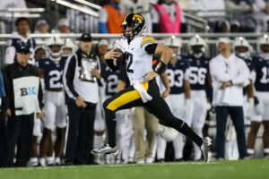 Iowa Hawkeyes quarterback Cade McNamara (12) runs with the ball during the first quarter against the Penn State Nittany Lions at Beaver Stadium. 