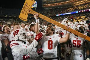 Wisconsin Badgers quarterback Tanner Mordecai (8) hoists Paul BunyanÕs Axe after defeating the Minnesota Golden Gophers to claim the rivalry trophy at Huntington Bank Stadium. Photo by Nick Wosika-USA TODAY Sports