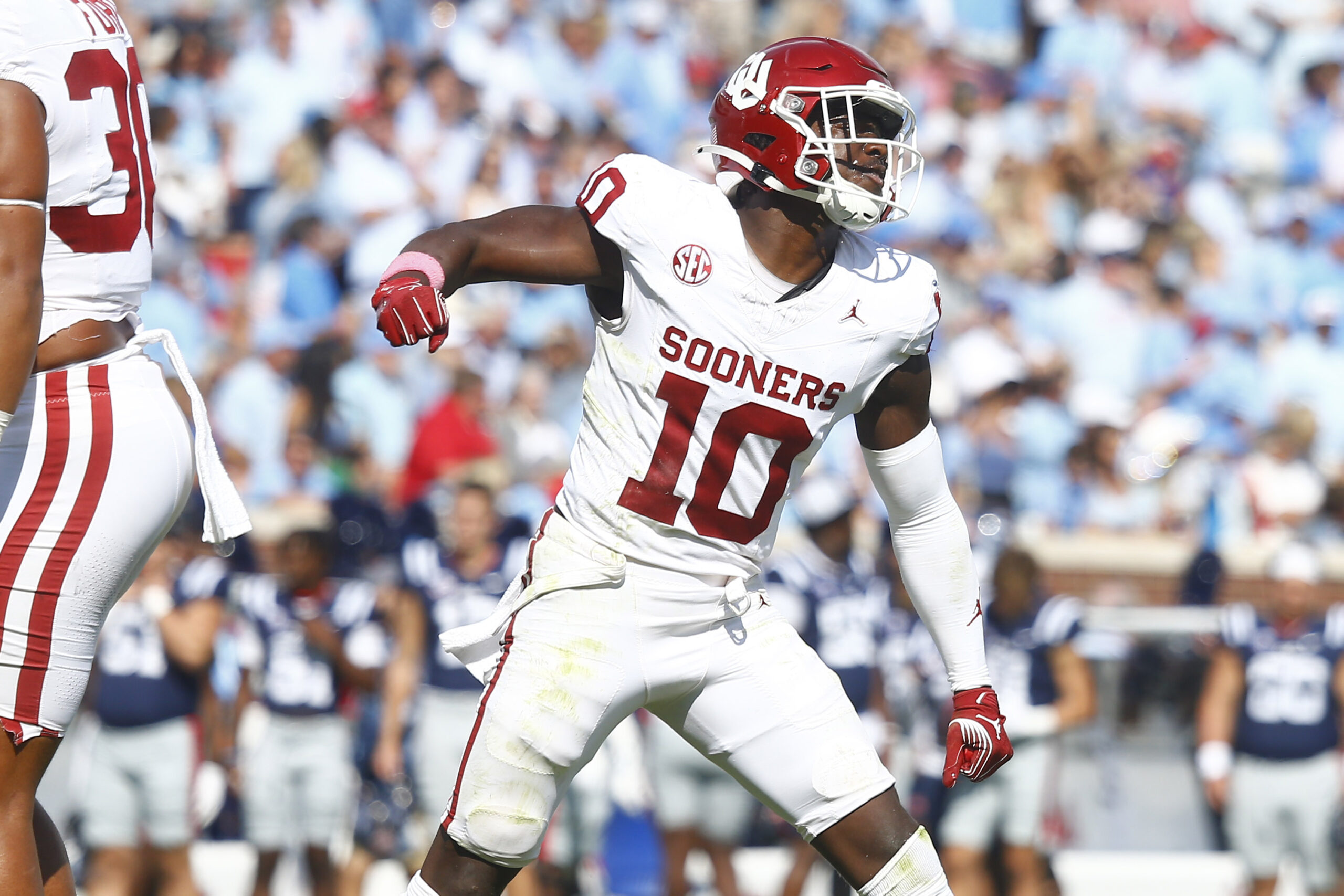 Home 11 Oklahoma Sooners linebacker (white jersey, red helmet, white pants) Kip Lewis celebrates a tackle against the Ole Miss Rebels.