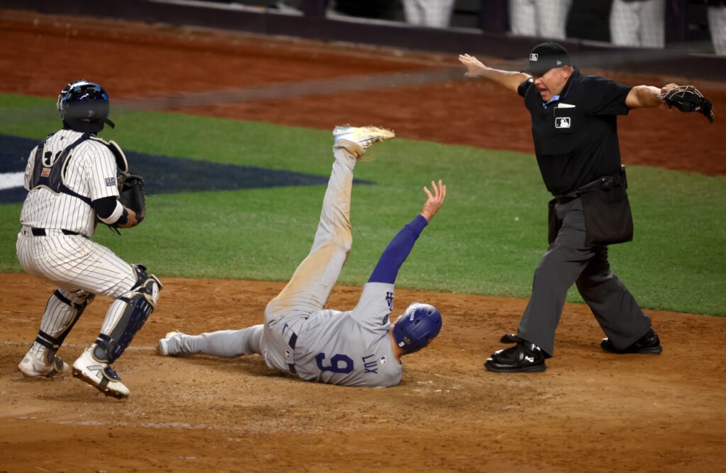 MLB home plate umpire Mark Carlson calls Los Angeles Dodgers second baseman Gavin Lux (9) safe against New York Yankees catcher Jose Trevino (39) during the sixth inning in game three of the 2024 MLB World Series at Yankee Stadium.